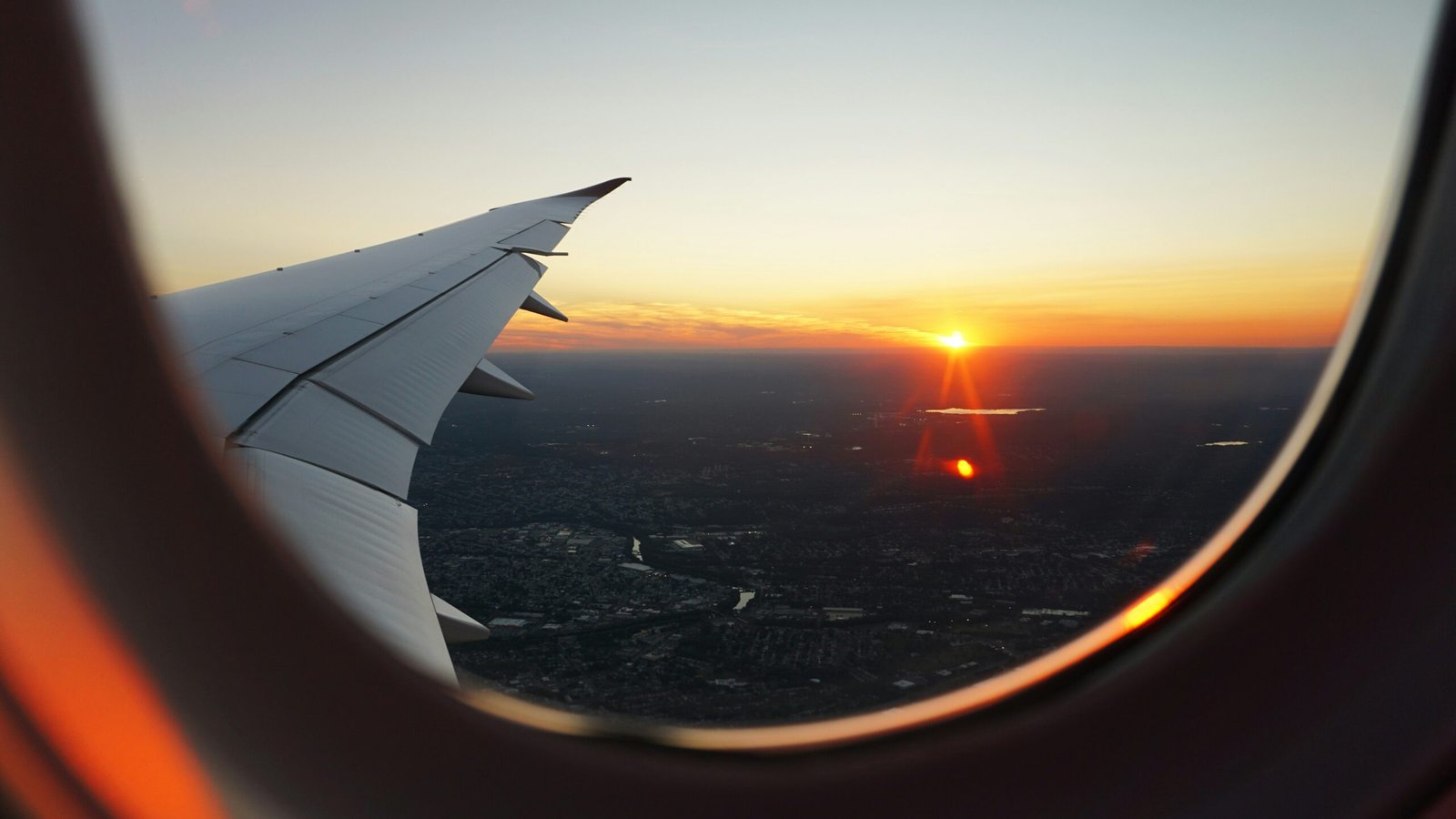 View from an airplane window at sunrise during a long-haul flight, illustrating jet lag recovery challenges