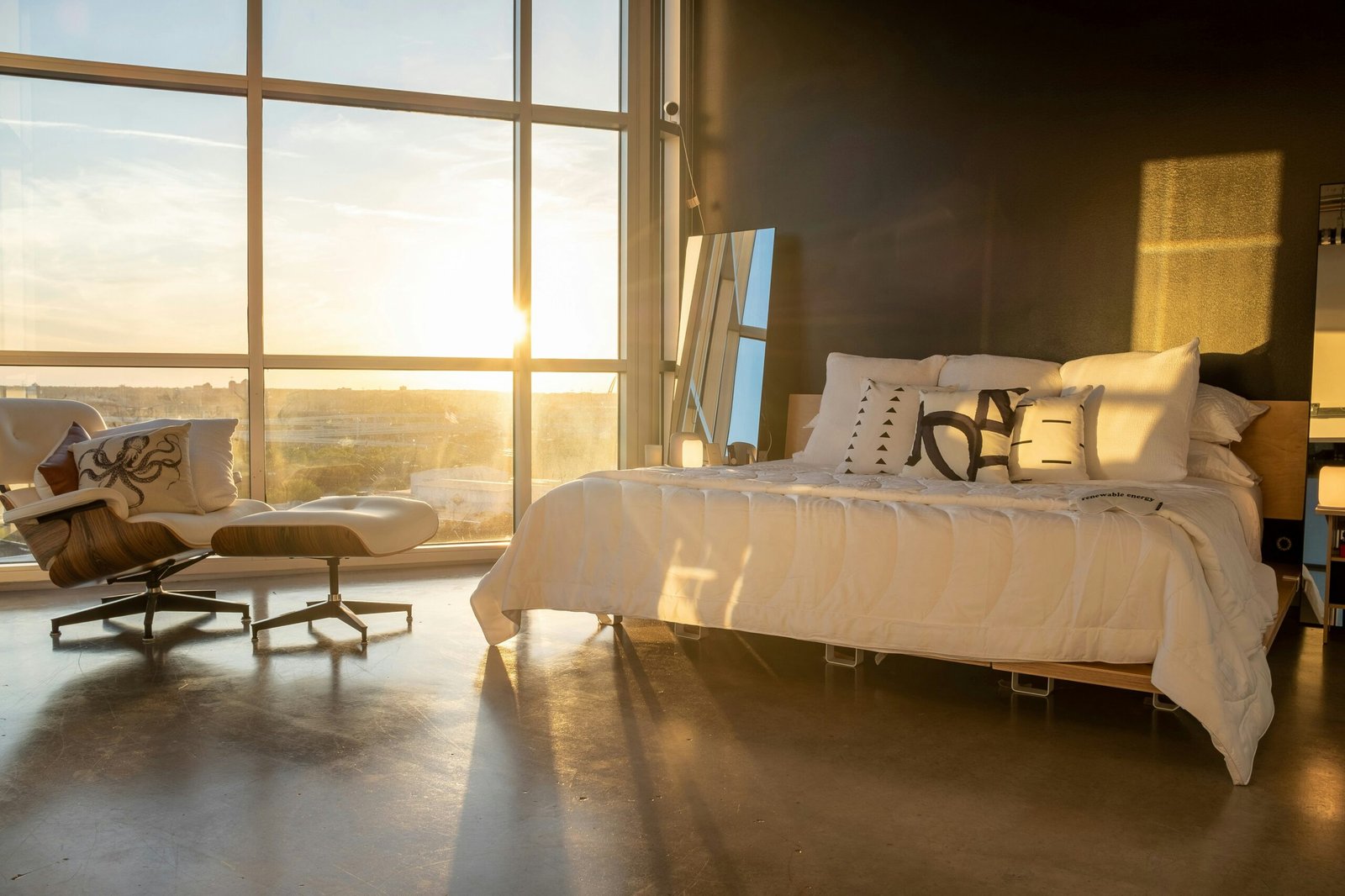 Modern bedroom with platform bed, white sheets and a supportive mattress in soft morning light