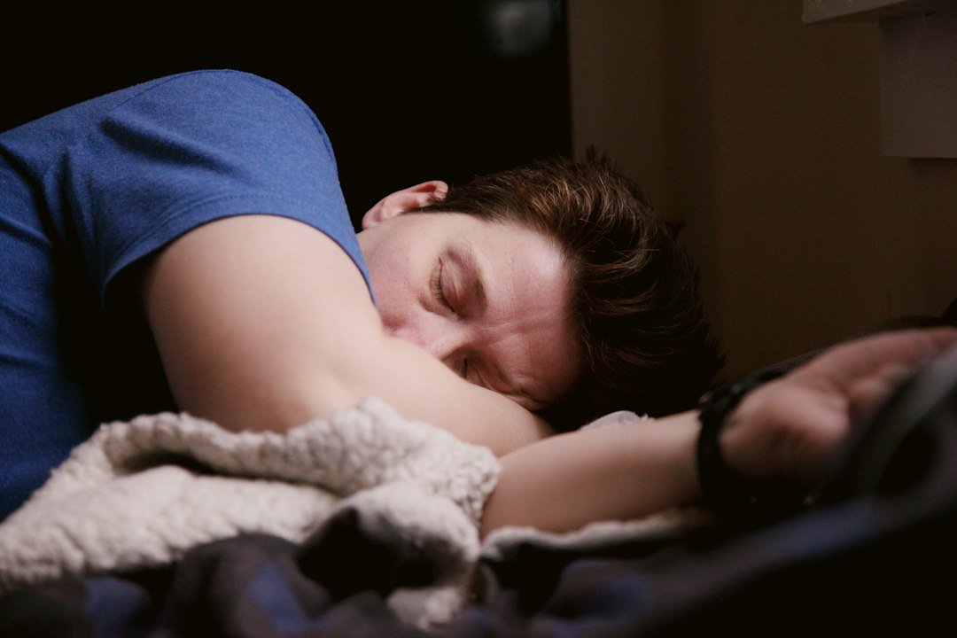 Person resting peacefully in bed with soft natural light